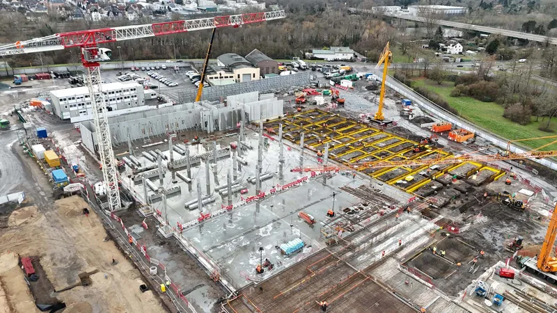 Frankfurt am Main'deki FRA07 veri merkezi şantiyesinin havadan görünümü: betonarme kolonlar, döşeme kalıpları ve kule vinçler