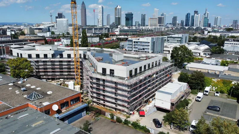 Frankfurt am Main'de iskeleli Myhatten otel binası ve kule vinç; arka planda Frankfurt silueti, havadan görünüm