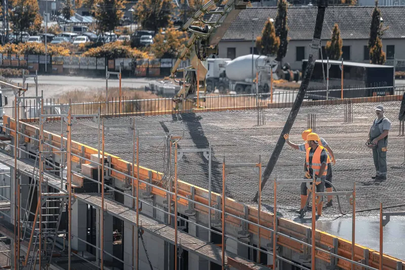 Langen'deki ofis binası ve kreş projesinde döşemeye pompa ile beton döken baretli ekip