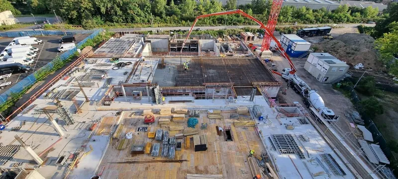 Ginsheim-Gustavsburg'daki Polis Eğitim Merkezi şantiyesi: donatısı döşenmiş döşeme, beton pompası ve vinç, havadan görünüm