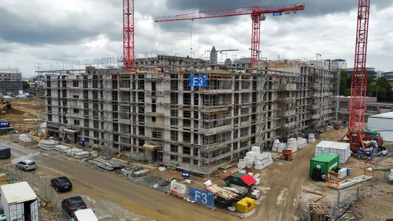 Frankfurt am Main Schönhofviertel F3'te iskeleli konut binasının kaba inşaatı ve üç kırmızı kule vinç